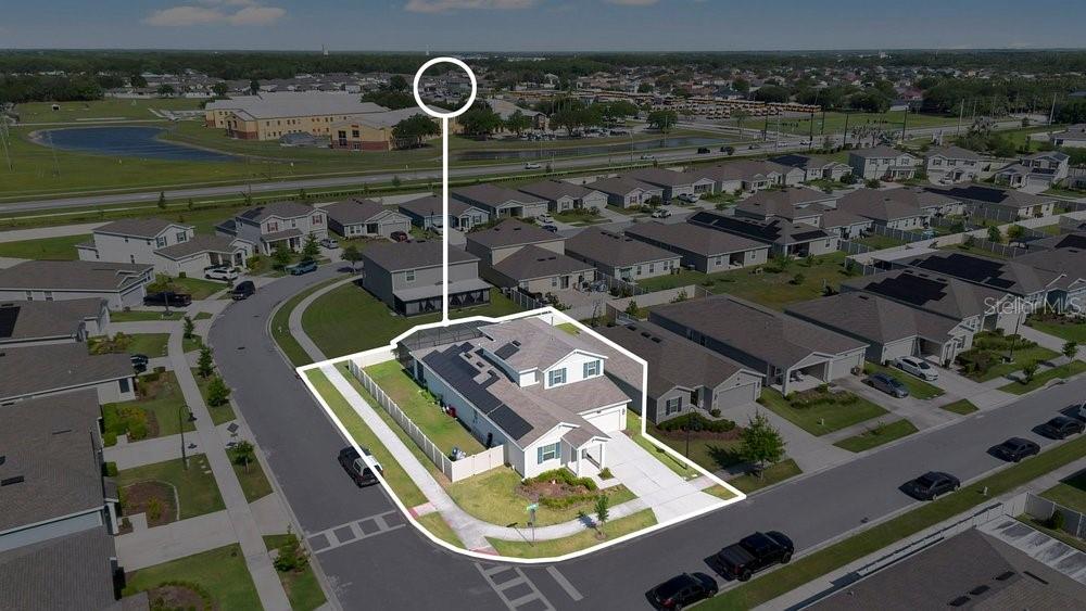 An aerial view shows a single-family house with a fenced backyard and solar panels — 2068 LIVE OAK RIDGE ROAD, KISSIMMEE, FL