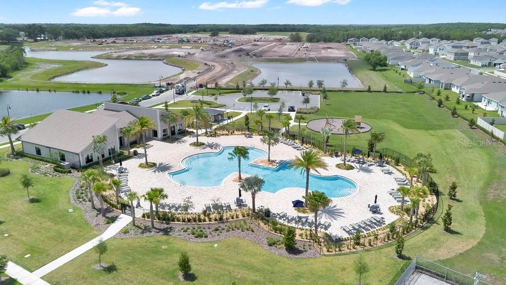 An aerial view shows a community swimming pool, clubhouse, playground, and surrounding residential development — 2068 LIVE OAK RIDGE ROAD, KISSIMMEE, FL