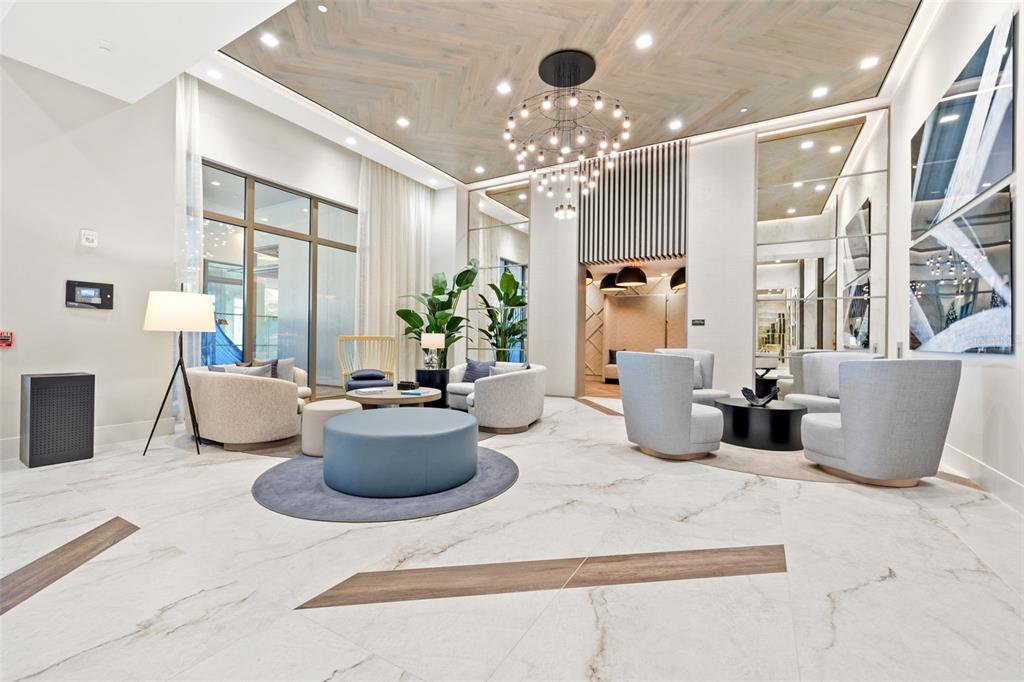 A modern lobby features marble floors, a herringbone wood ceiling, and contemporary lounge seating — 301 1ST STREET S UNIT 3205, ST PETERSBURG, FL
