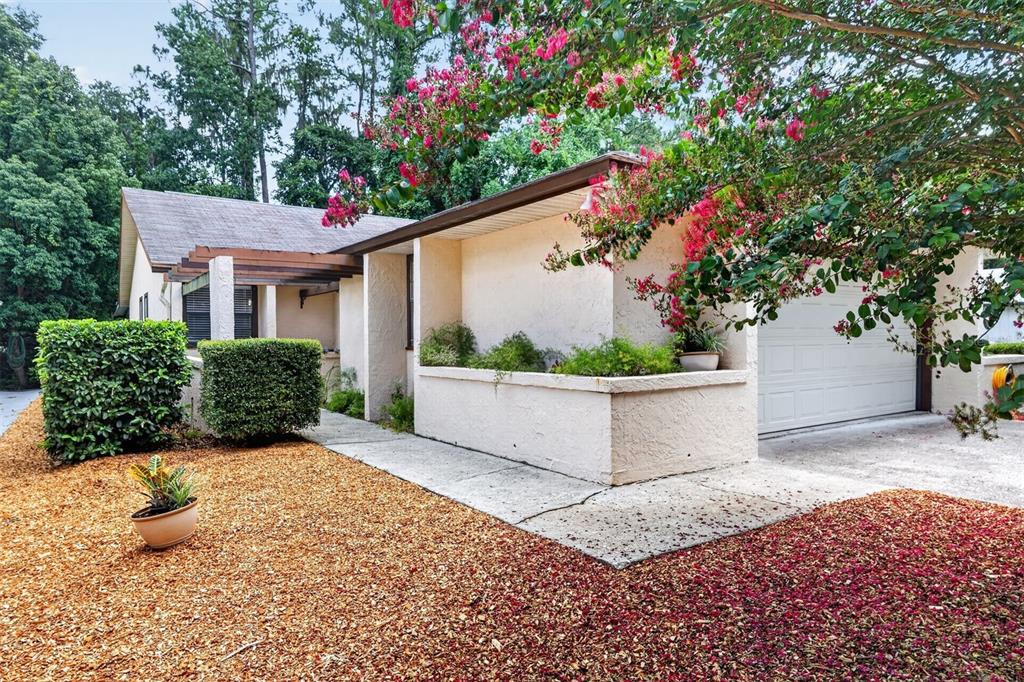 A single-story house exterior features a concrete walkway, a planter box, and a garage — 8391 NW 39TH CIRCLE, GAINESVILLE, FL