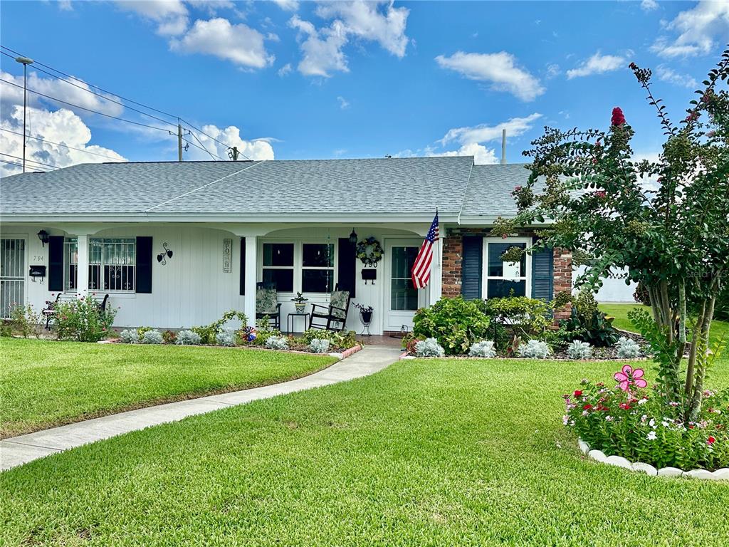 A single-story house with a white facade, brick accents, a front porch, and a lawn — 790 AVENUE Q SE, WINTER HAVEN, FL