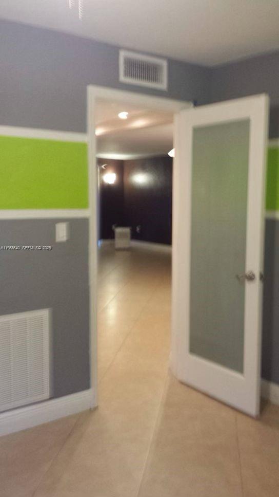 A doorway with a frosted glass panel door leads into a room with dark walls — 7368 SW 82nd St # E113, Miami FL 33143, MIAMI, FL