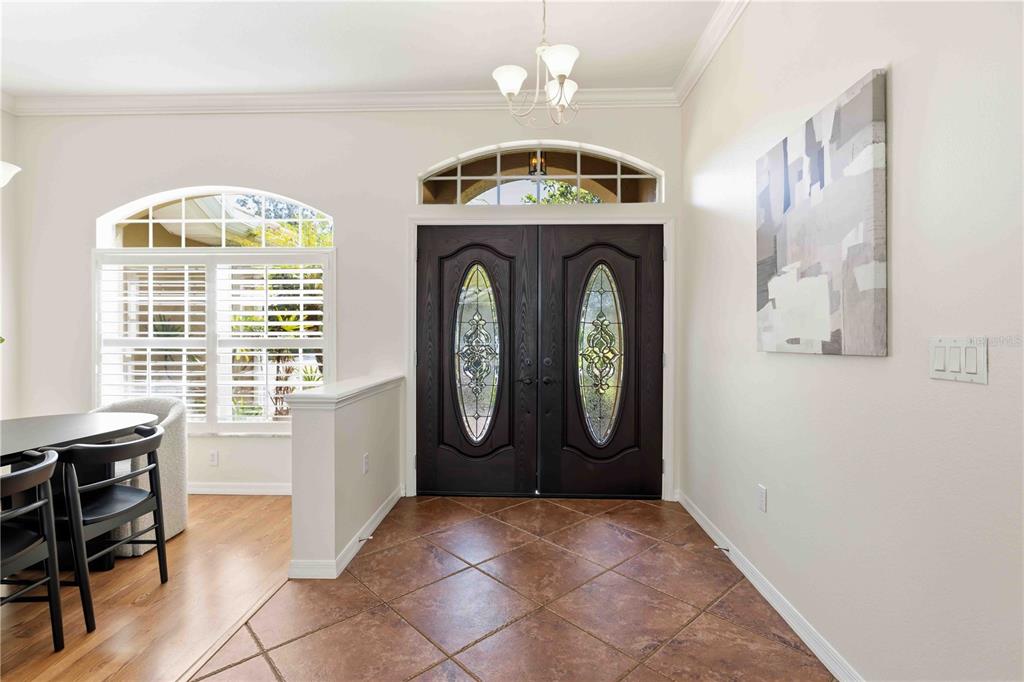 An entryway features dark double doors with glass inserts, tile flooring, and a dining area nearby — 4742 OLD FARM ROAD, SARASOTA, FL