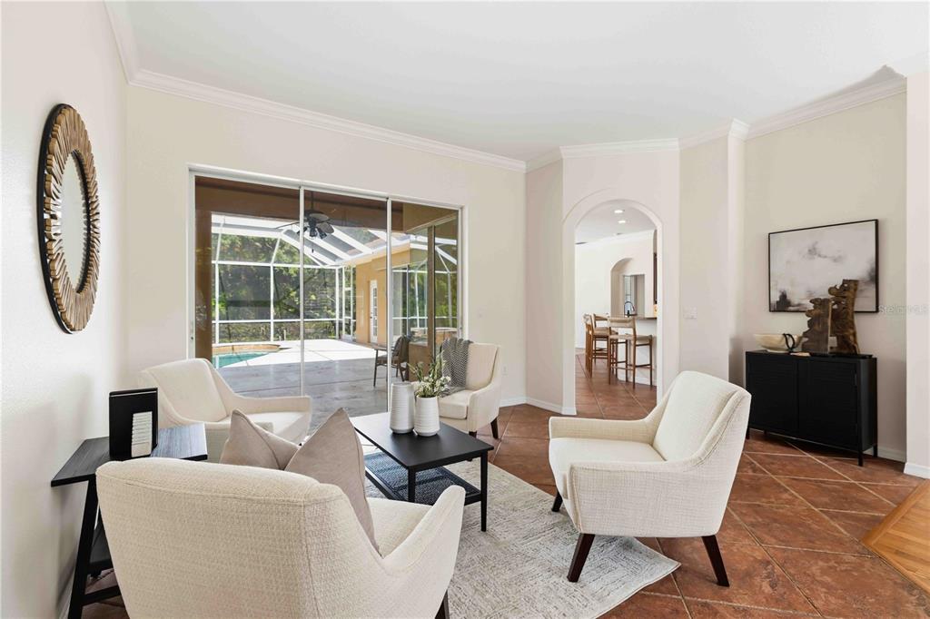 A living room with four cream armchairs, a coffee table, and sliding doors to a pool — 4742 OLD FARM ROAD, SARASOTA, FL