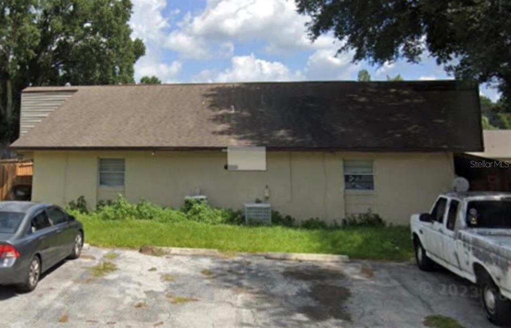 A beige, single-story building with a brown shingled roof sits behind a paved parking lot — 5121 SE 30TH STREET, OCALA, FL