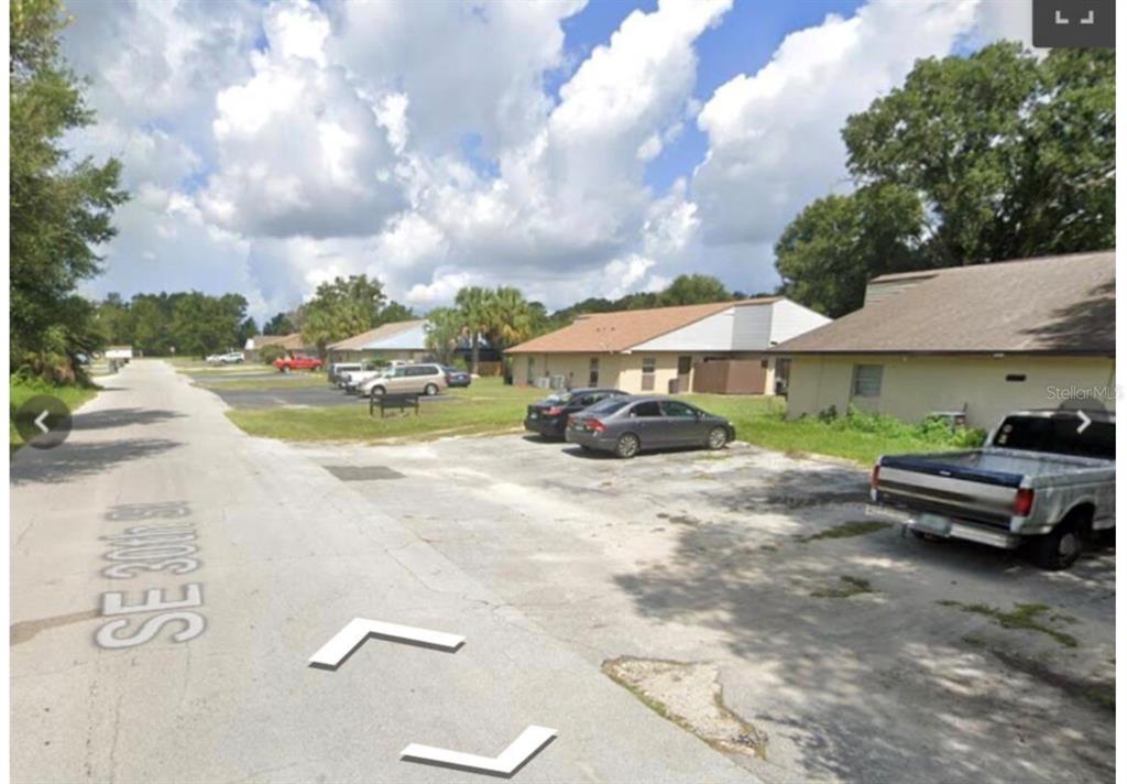 A view of a paved parking area in front of single-story residential buildings — 5121 SE 30TH STREET, OCALA, FL