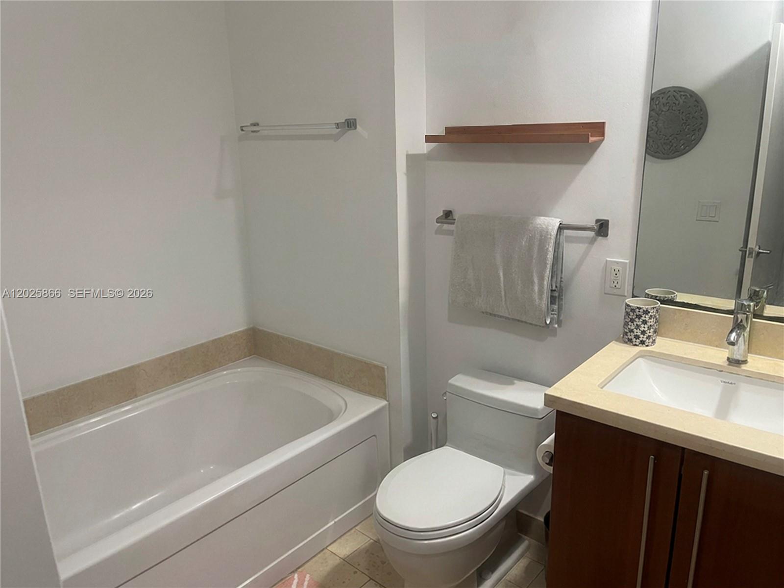 A bathroom features a white bathtub, a toilet, and a vanity with a sink — 79 SW 12 ST, Miami FL 33130, MIAMI, FL