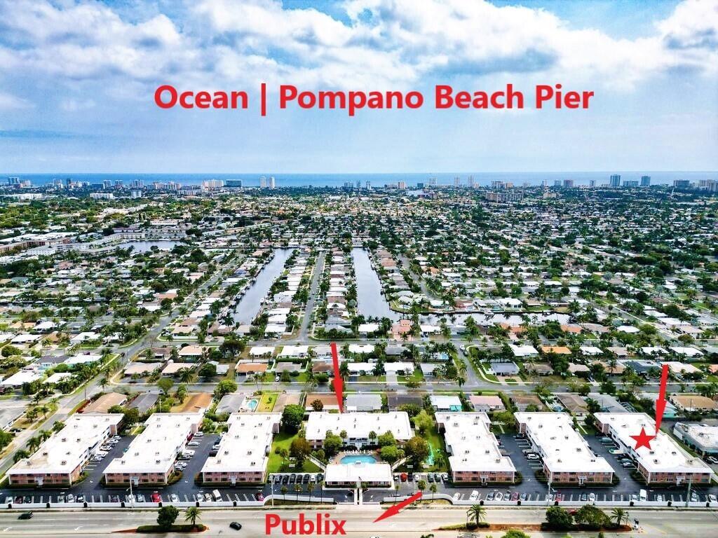 Aerial view of a residential complex with a pool, near a road and the ocean — 418 S Cypress Road # 128, Pompano Beach FL 33060, POMPANO BEACH, FL