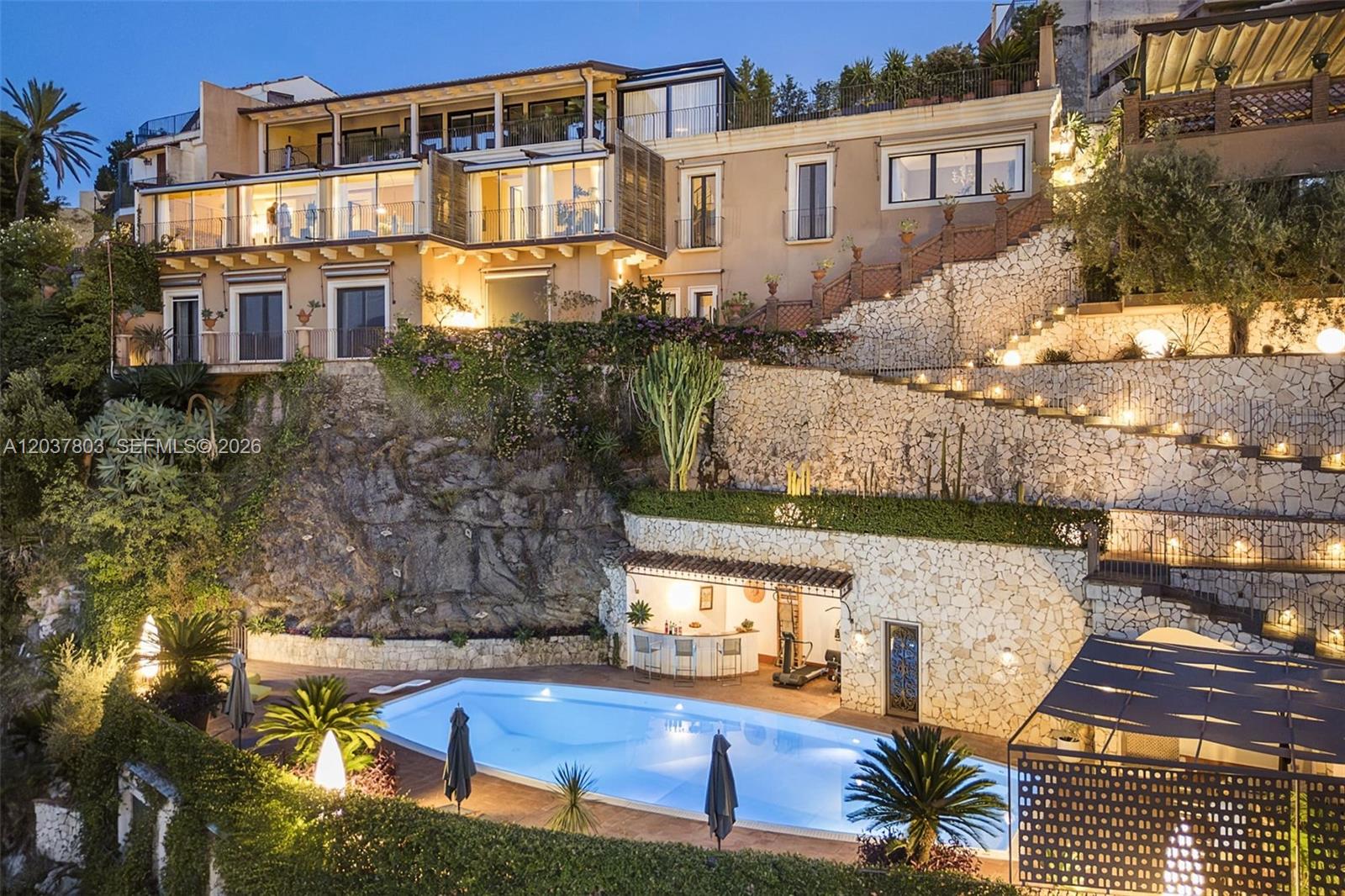 A multi-level villa with a swimming pool, stone retaining walls, and terraced outdoor spaces — 1 Mazzaro, FL, FL
