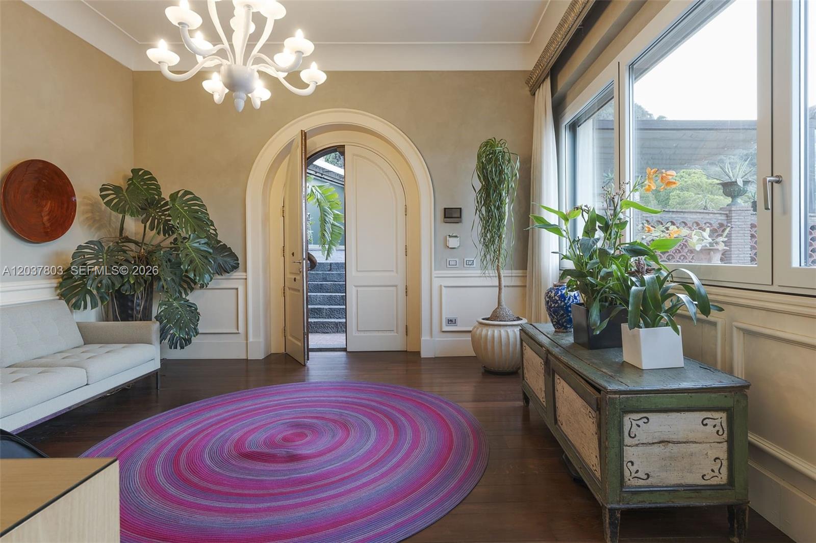 A living room features an arched doorway, a purple circular rug, and a white chandelier — 1 Mazzaro, FL, FL