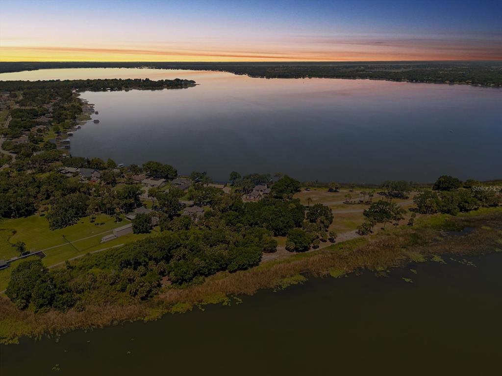 An aerial view shows a residential neighborhood situated along the shore of a large lake — TBD DEER ISLAND ROAD, TAVARES, FL