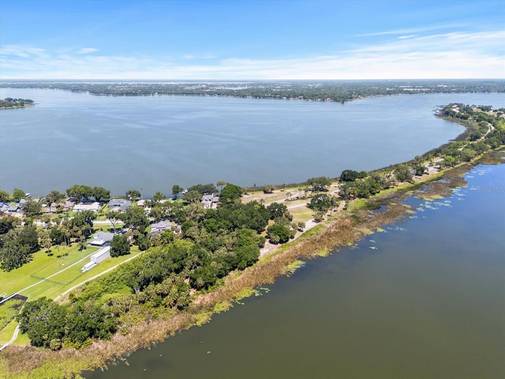 An aerial view shows a narrow strip of land separating two bodies of water — TBD DEER ISLAND ROAD, TAVARES, FL