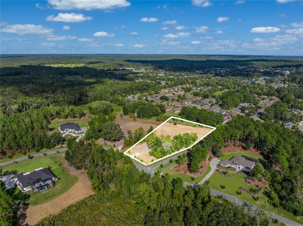 An aerial view shows a vacant, irregularly shaped residential lot surrounded by trees and houses — TBD NW 150TH BOULEVARD, NEWBERRY, FL