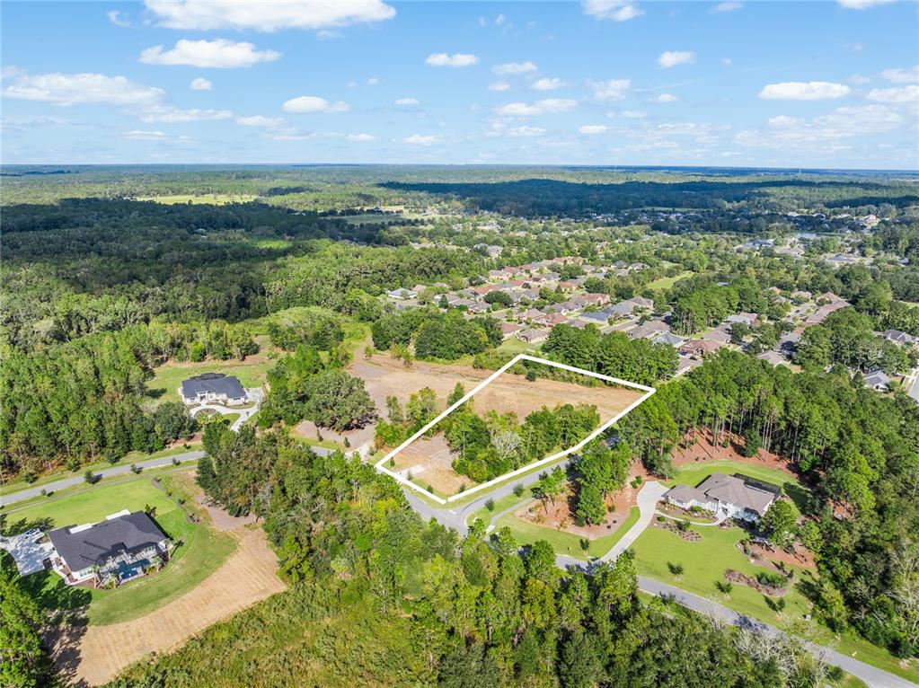 An aerial view shows a vacant, rectangular lot outlined in white within a wooded neighborhood — TBD NW 150TH BOULEVARD, NEWBERRY, FL