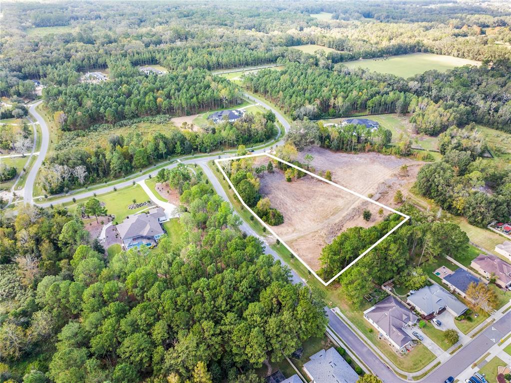 An aerial view shows a vacant, partially wooded residential lot outlined in white — TBD NW 150TH BOULEVARD, NEWBERRY, FL