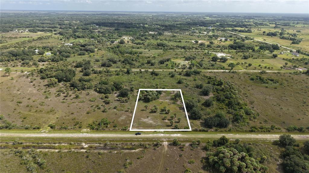 An aerial view shows a rectangular plot of land outlined in white beside a road — 14773 NW 280TH STREET, OKEECHOBEE, FL