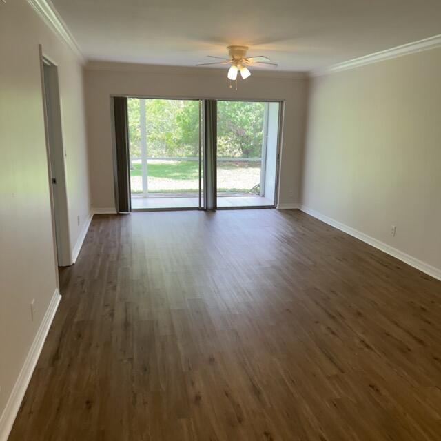 An empty living room features wood-look flooring, a ceiling fan, and sliding glass doors — 1900 S Kanner Hwy Highway Apt 102, Stuart FL 34994, STUART, FL