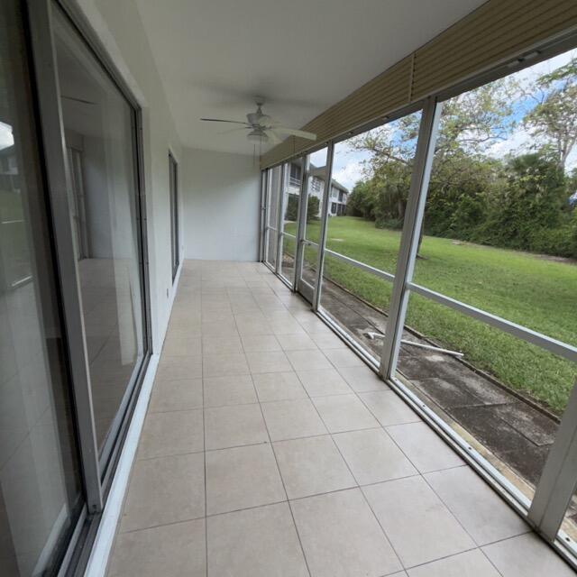 A long, tiled screened-in porch features a ceiling fan and views of a grassy yard — 1900 S Kanner Hwy Highway Apt 102, Stuart FL 34994, STUART, FL