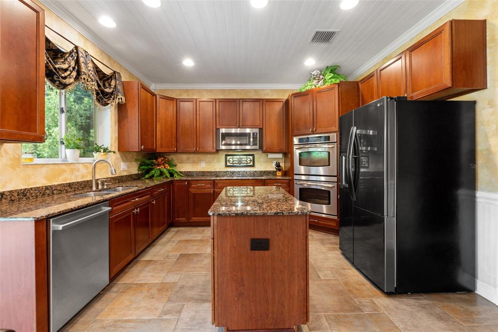 A high-angle view of a staircase with wooden treads and black metal railings — 7445 MINNOW BROOK WAY, LAND O LAKES, FL