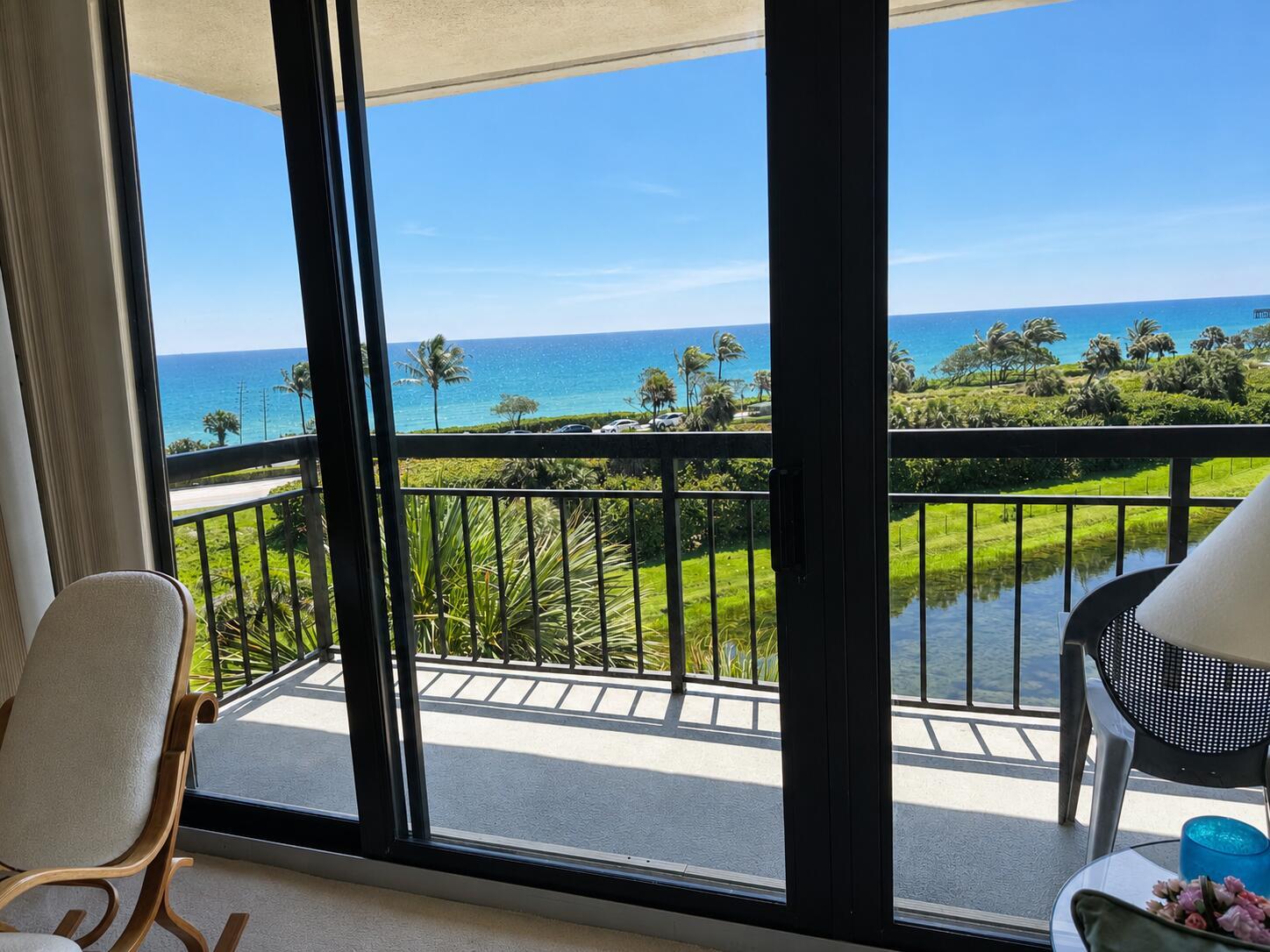 A view of the ocean and a pond from a balcony with sliding glass doors — 101 S Seas Drive # 505, Jupiter FL 33477, JUPITER, FL