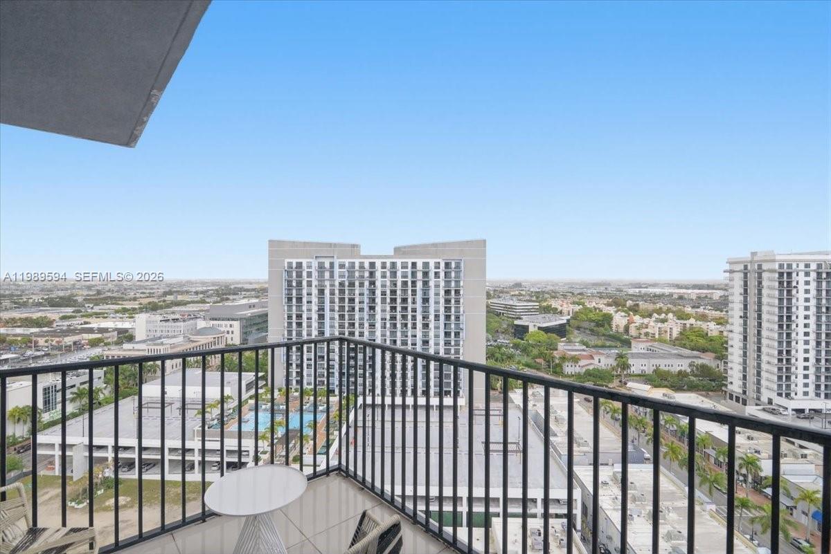 A balcony with a metal railing overlooks a suburban landscape with several high-rise buildings — 5300 Paseo Blvd # 1803, Doral FL 33166, DORAL, FL