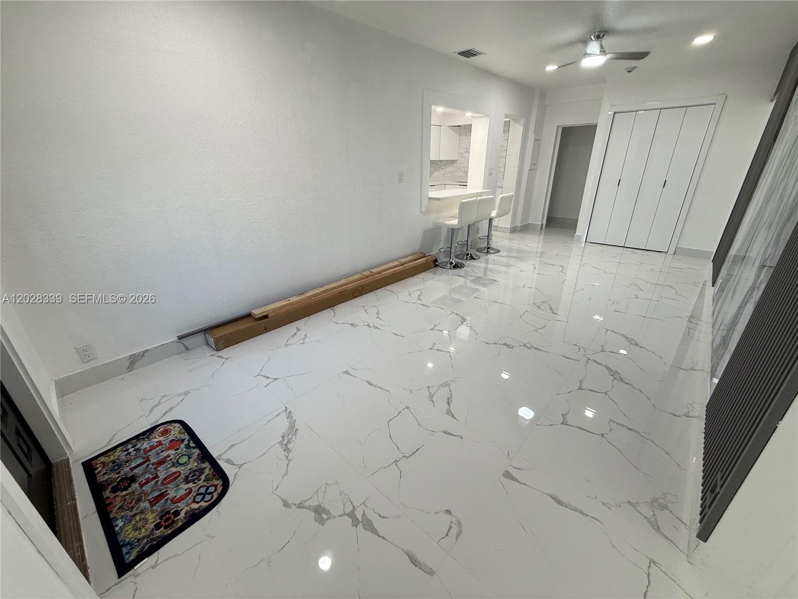 A room with white marble-patterned tile flooring, a breakfast bar, and white walls — 6520 W 8th Ln # 2, Hialeah FL 33012, HIALEAH, FL