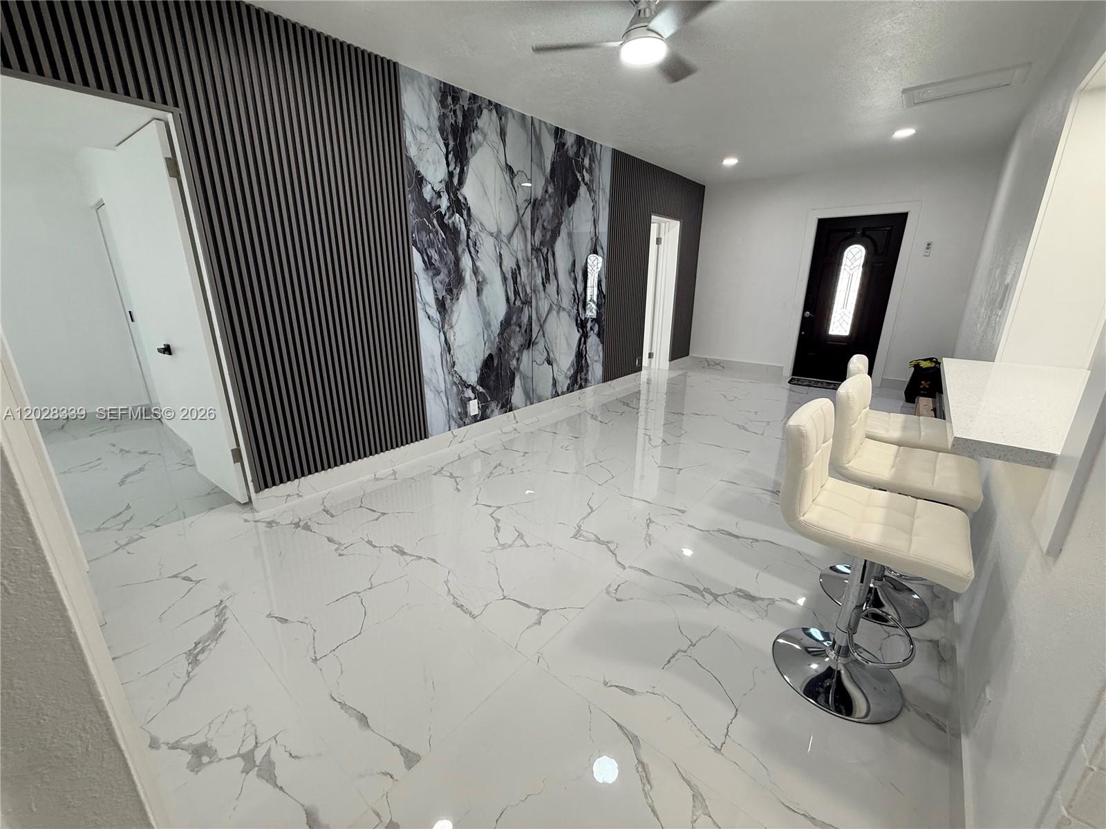 A room features white marble-look tile flooring, a slatted wall, and a central marble accent — 6520 W 8th Ln # 2, Hialeah FL 33012, HIALEAH, FL