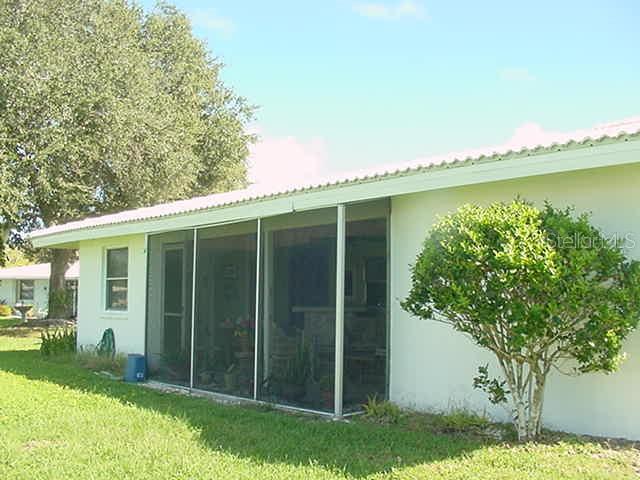 A light-colored house features a screened-in porch and a large tree in the yard — 519 CIRCLEWOOD DRIVE UNIT 519, VENICE, FL