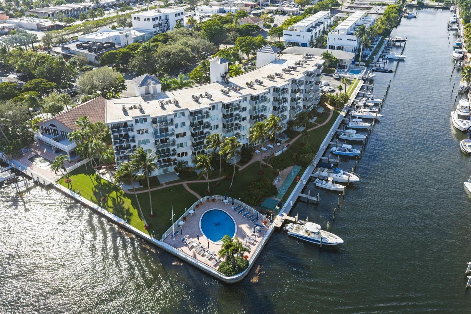 An aerial view of a waterfront condominium complex with a pool and private boat slips — 140 NE 28th Avenue # 406, Pompano Beach FL 33062, POMPANO BEACH, FL