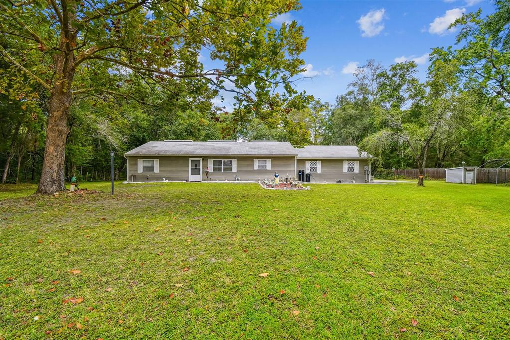 A single-story house with a garage and a large front lawn under a blue sky — 9741 STAR TRAIL, NEW PORT RICHEY, FL