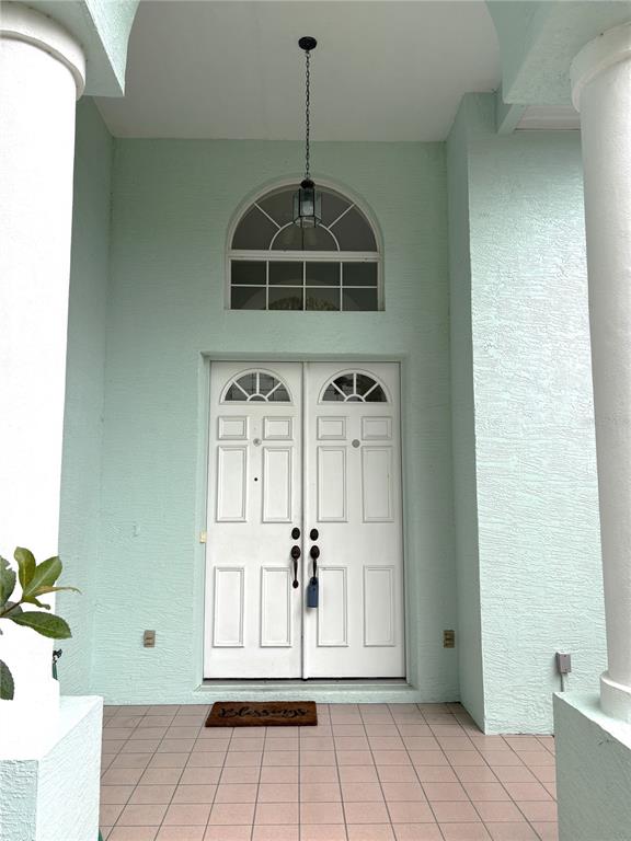 A light green exterior entryway features double white doors, a transom window, and tiled flooring — 9670 SW 190TH TERRACE ROAD, DUNNELLON, FL