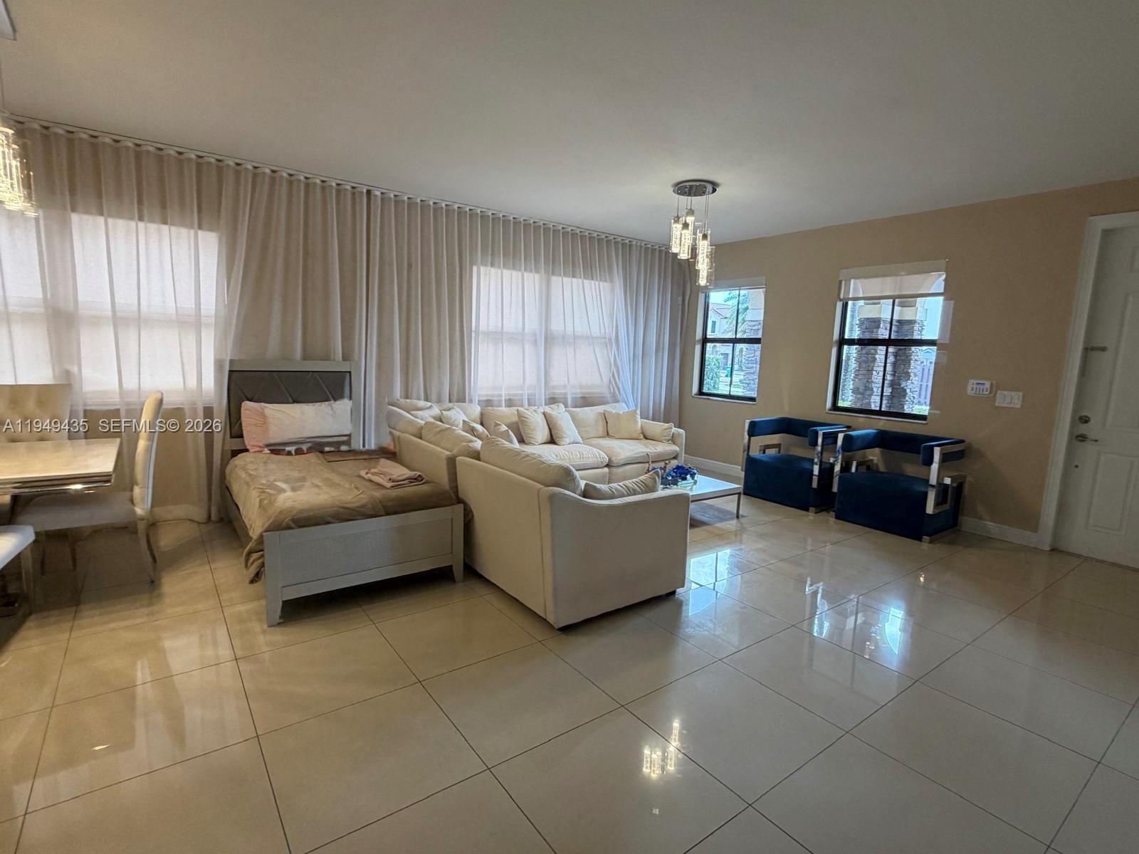 A living room features light tile floors, a white sectional sofa, and two blue chairs — 9855 NW 89th Ter, Doral FL 33178, DORAL, FL