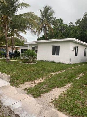 A single-story white house with a flat roof sits on a grassy lot with palm trees — 809 NE 140th St, North Miami FL 33161, NORTH MIAMI, FL