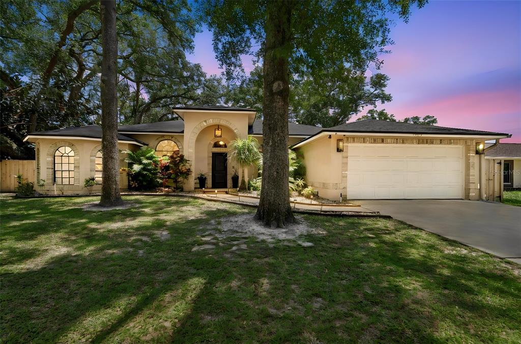 A single-story house with a beige stucco exterior, arched entryway, and a two-car garage — 3602 ARLINGTON OAKS COURT, TAMPA, FL
