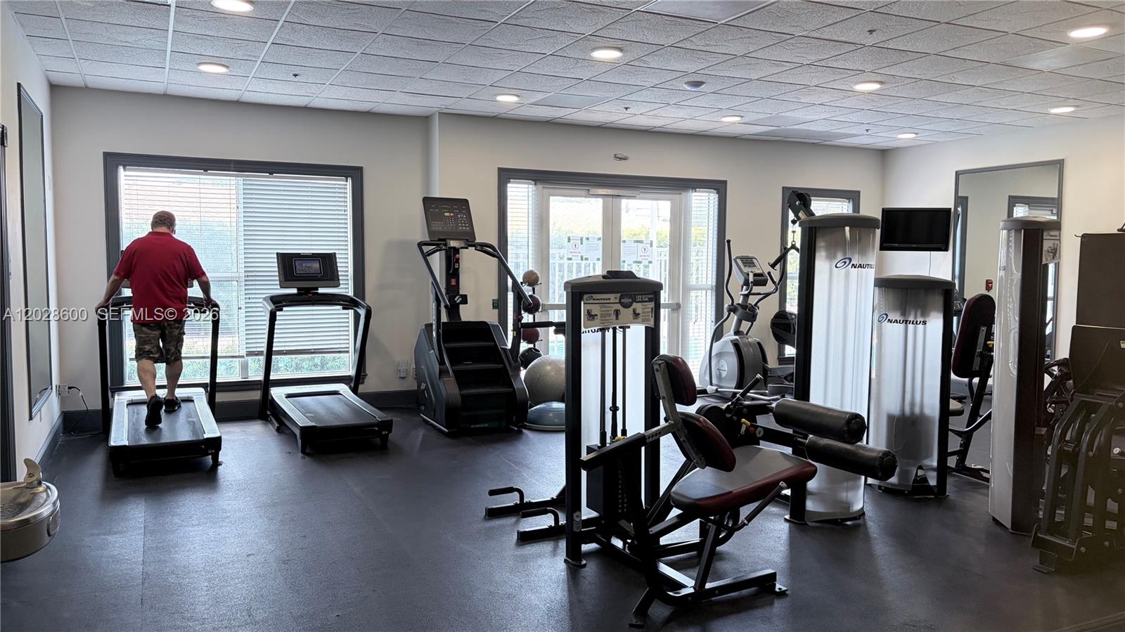 A gym room features various exercise machines, including treadmills, a stair climber, and weight equipment — 2665 SW 37th Ave # 405, Miami FL 33133, MIAMI, FL