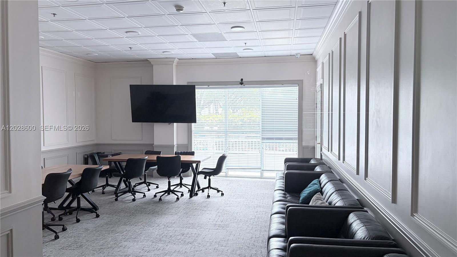 A conference room features a large television, several office chairs, and a long leather sofa — 2665 SW 37th Ave # 405, Miami FL 33133, MIAMI, FL