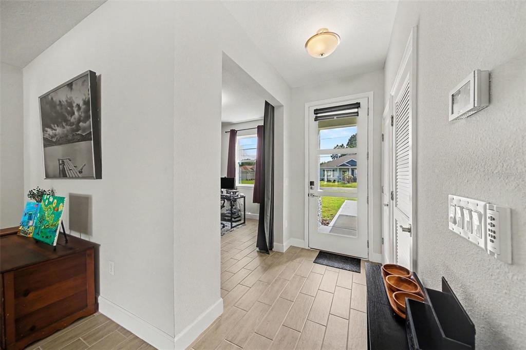 An entryway with tile flooring, a glass-paneled front door, and a view into a room — 12 LANSING LANE, PALM COAST, FL