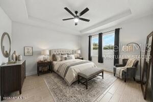 A bedroom features a tray ceiling, ceiling fan, neutral walls, and a large area rug — 12 LANSING LANE, PALM COAST, FL