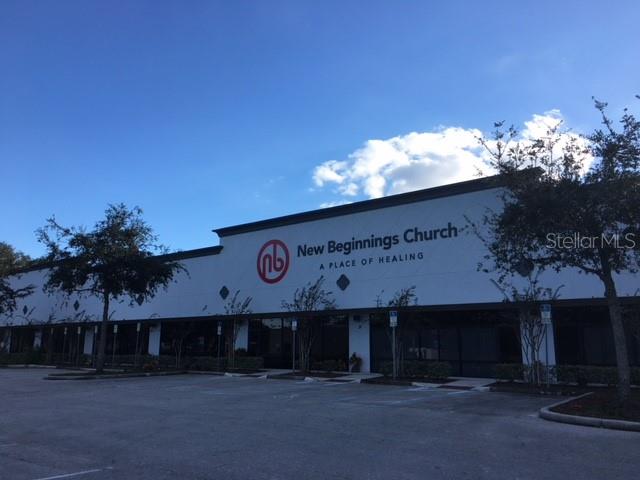 The exterior of a commercial building features signage for New Beginnings Church and a parking lot — 6859 EDGEWATER COMMERCE PARKWAY, ORLANDO, FL