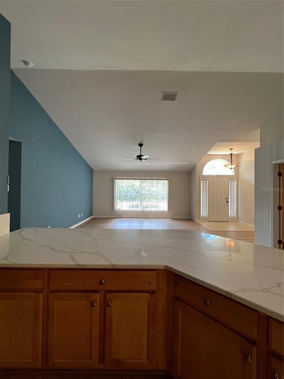 A kitchen counter with white marble-look countertops overlooks a living area with blue walls — 2634 TWINKLE AVENUE, NORTH PORT, FL