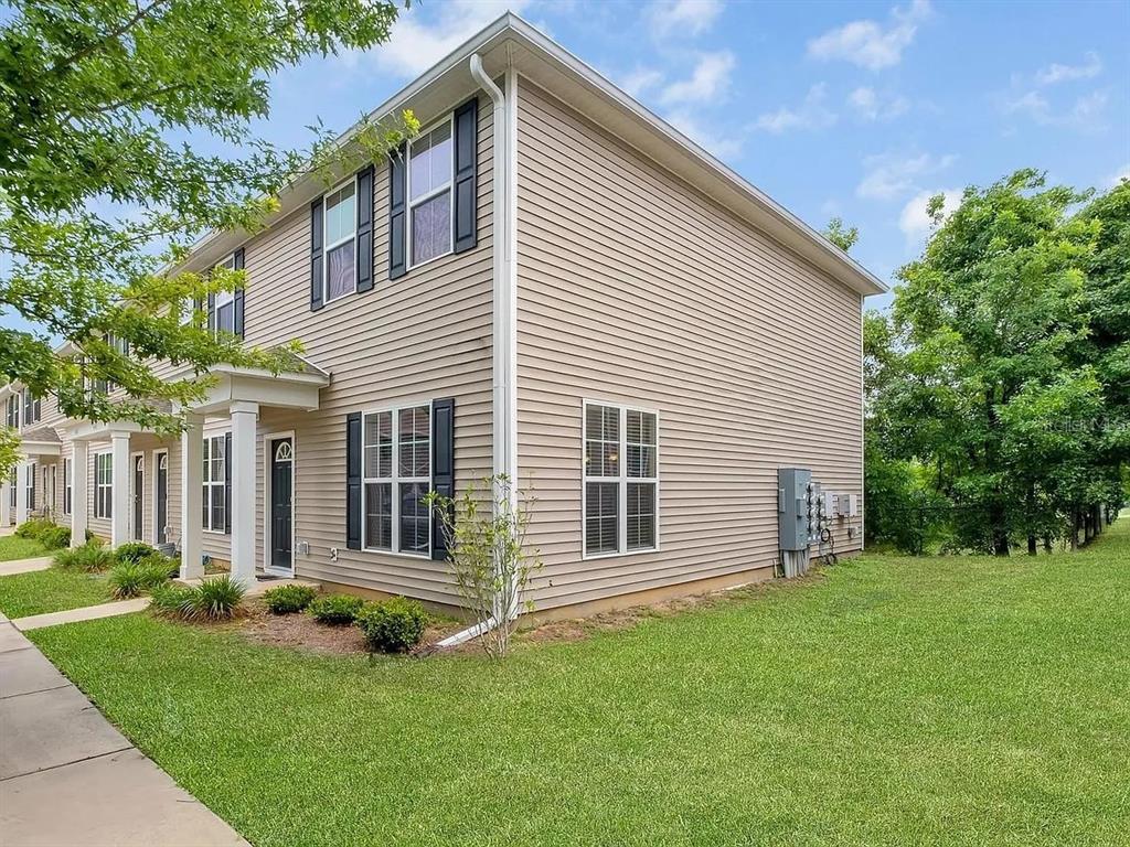 A two-story townhouse with beige vinyl siding and a small front porch — 3660 TYSON GREEN WAY UNIT 707, TALLAHASSEE, FL