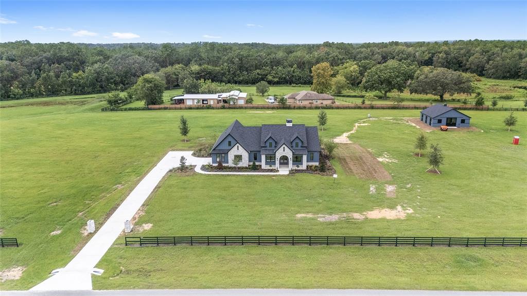 An aerial view shows a blue house with a dark roof on a large grassy lot — 11324 NW 50 LANE, OCALA, FL