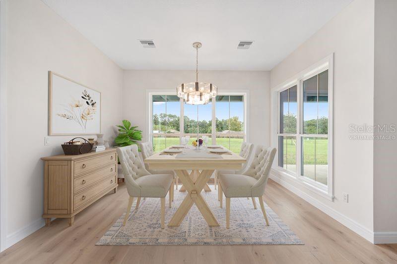 A dining room with a wooden table, tufted chairs, a sideboard, and large windows — 11324 NW 50 LANE, OCALA, FL