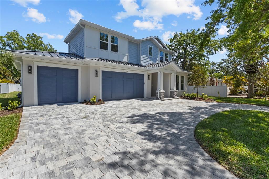A two-story house with blue siding, a three-car garage, and a paved stone driveway — 217 S SHADE AVENUE, SARASOTA, FL
