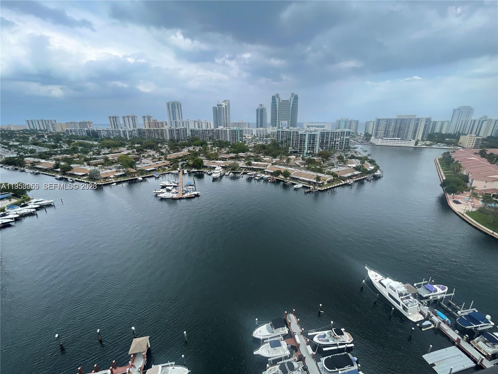 An elevated view shows a marina with docked boats and a city skyline beyond — 300 Three Islands Blvd # 417, Hallandale Beach FL 33009, HALLANDALE BEACH, FL