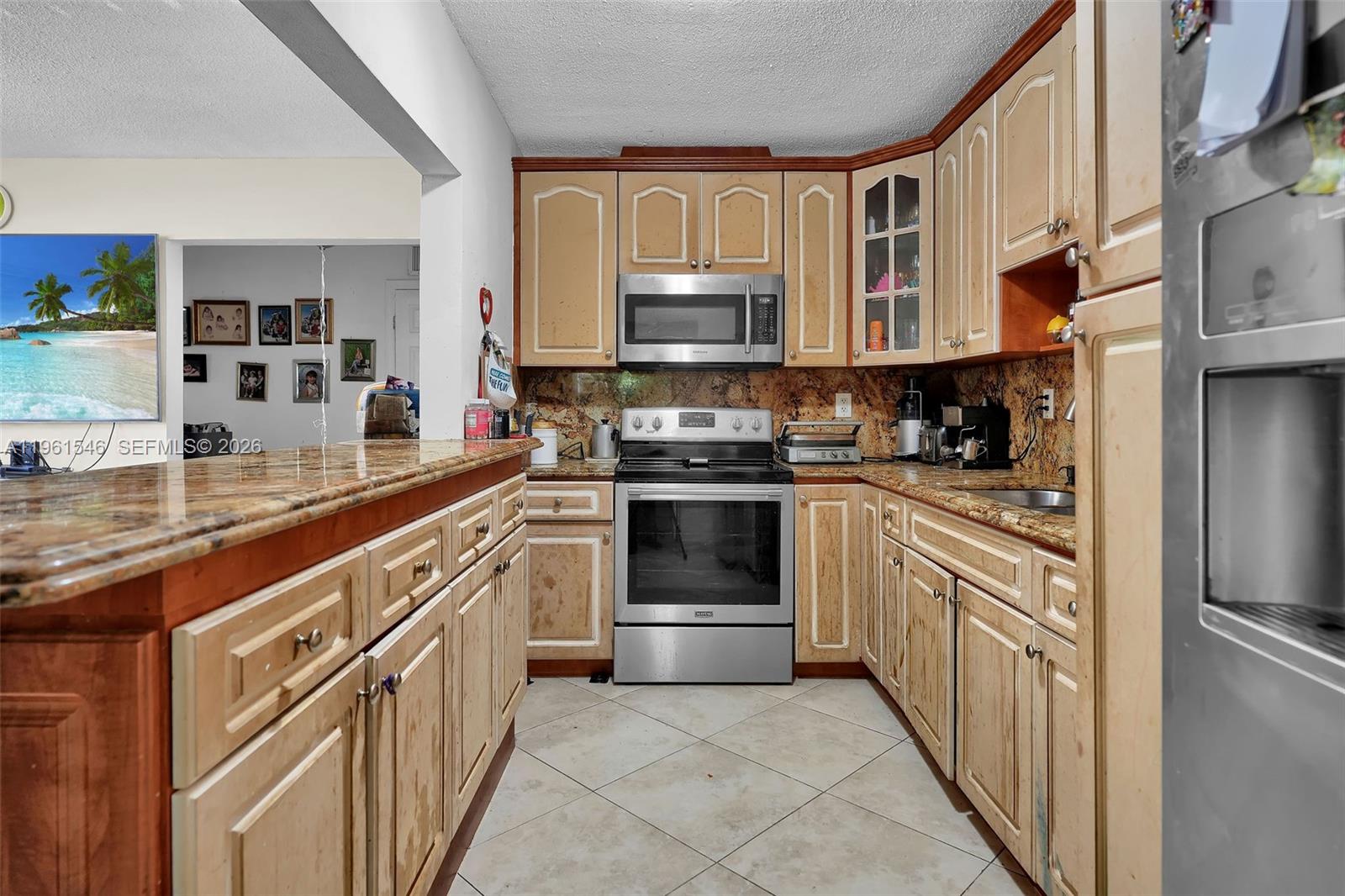 A kitchen features light wood cabinets, granite countertops, stainless steel appliances, and tile flooring — 2821 SW 65th Ave, Miami FL 33155, MIAMI, FL