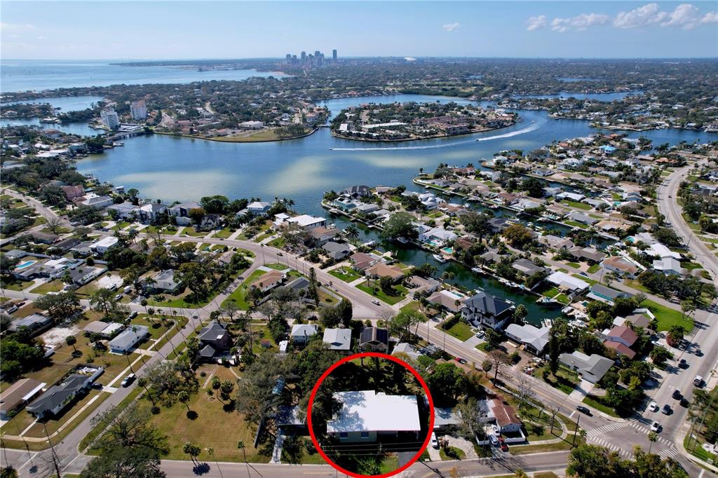 An aerial view shows a single-story house with a white roof circled in red — 4042 ARKANSAS AVENUE NE, ST PETERSBURG, FL