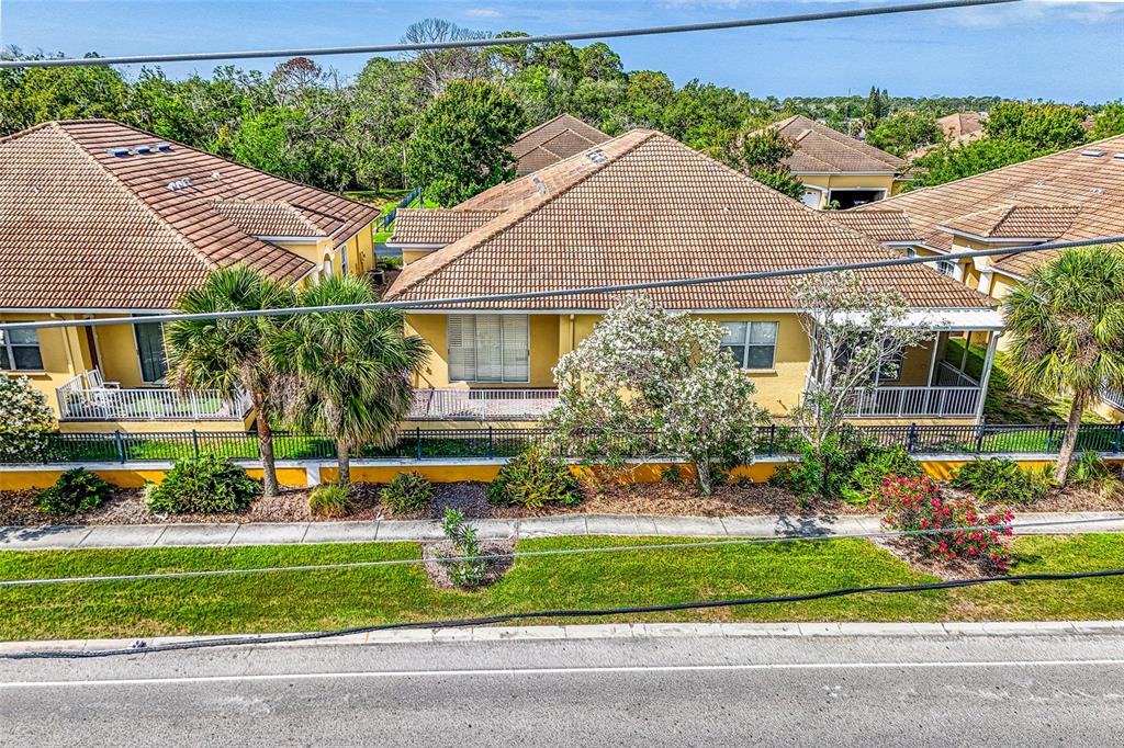 An exterior view of yellow residential buildings with tiled roofs and screened-in porches — 4717 CASSWELL DRIVE, NEW PORT RICHEY, FL