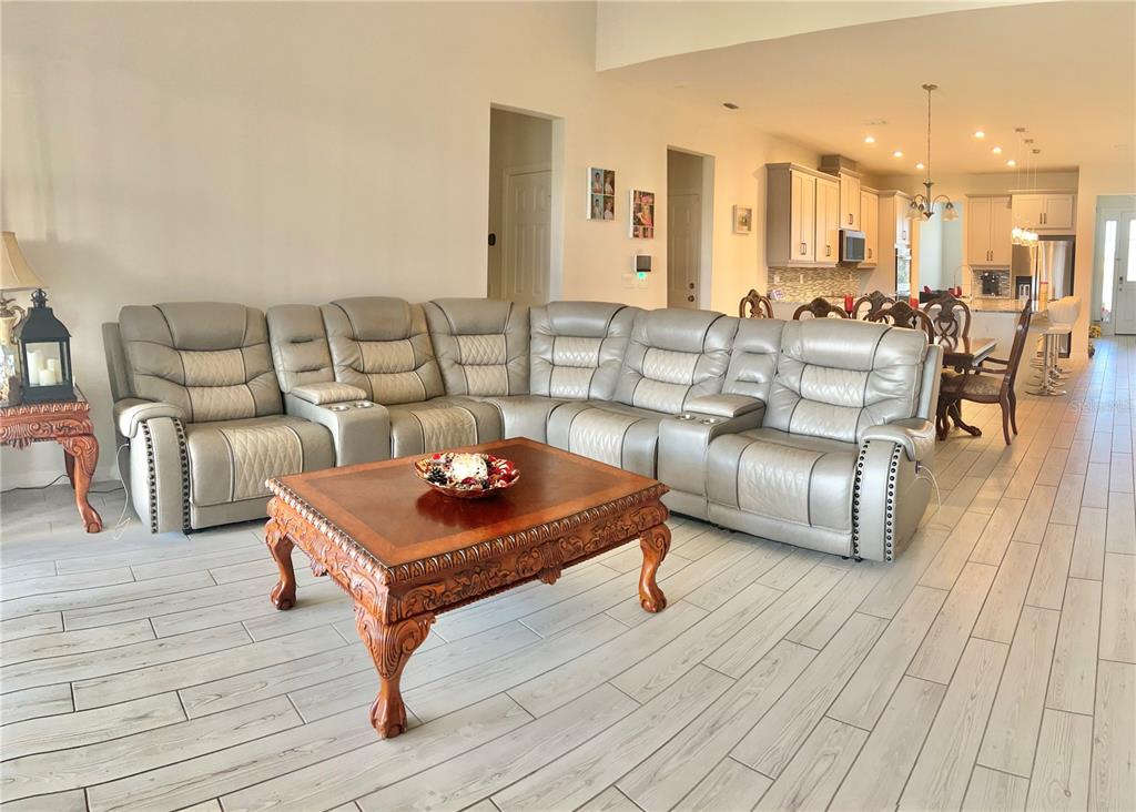 A living room features a large gray sectional sofa, a wooden coffee table, and tile flooring — 9552 LAUNCH POINT ROAD, ORLANDO, FL
