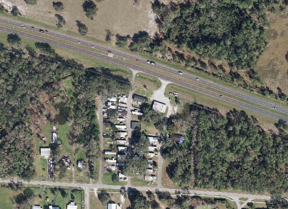 This aerial view shows a mobile home park situated between a highway and a road — 16194 E COLONIAL DRIVE, ORLANDO, FL